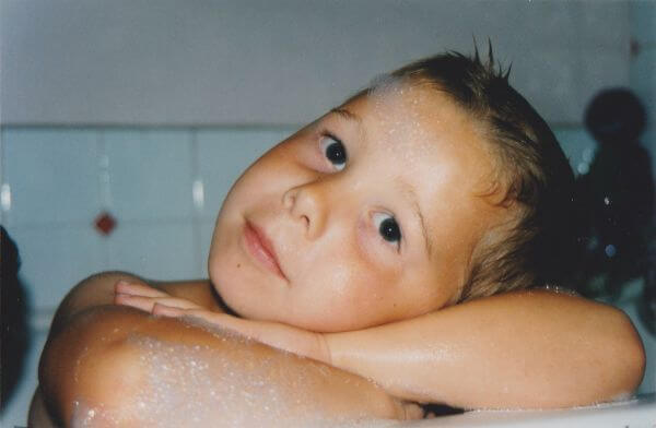 Conor, around age five, sat in the bathtub resting his head on his folded arms. There are bubbles on his arms and face and he is smiling, looking angelic.