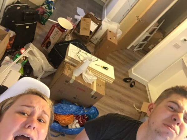 A selfie, taken by Laura, of the pair of them surrounded by boxes on the first night in their first ever flat together. They are jokingly pulling exasperated faces at the camera.